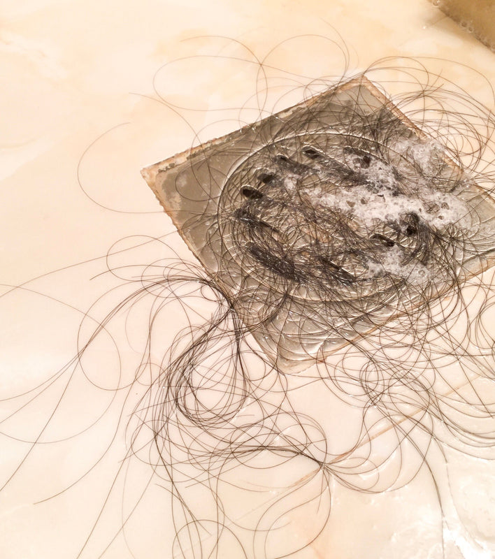 clump of hair in shower drain due to seasonal hair loss
