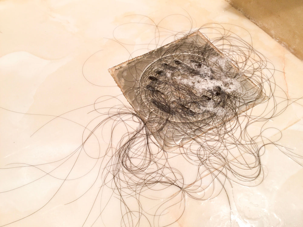 clump of hair in shower drain due to seasonal hair loss
