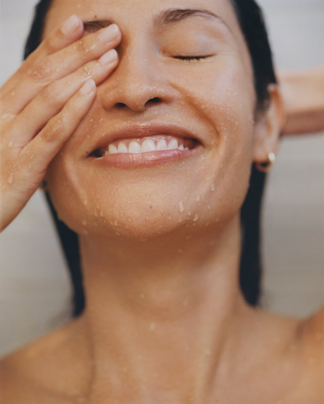 Person washing their face in the shower